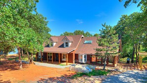 A two-story house with a covered porch, a garage, and a gravel driveway. - Spacious Retreat Near Norman Close to OU & Riverwind Casino (Blanchard)