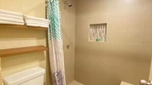 Une salle de bain avec des toilettes, une douche et une baignoire.