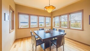 A dining room with a large table, six chairs, and a unique pendant light. - Waterfront Home w/ Beach access! (Port Ludlow)