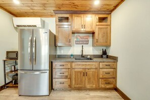 Una cucina con mobili in legno, un frigorifero in acciaio inossidabile, un lavandino e un cartello di benvenuto.