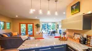 Una cocina moderna con una isla central, armarios empotrados e iluminación colgante.