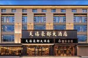 A hotel with a modern facade, large windows, and a prominent signage indicating it is a hotel. - Rongjiang Tianxi Haodu Hotel (Main Store at Cun Chao Football Field) (Rongjiang)