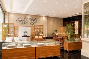 A hotel lobby with a reception desk, seating area, and decorative plants. - Rongjiang Tianxi Haodu Hotel (Main Store at Cun Chao Football Field) (Rongjiang)