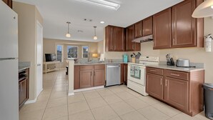 A modern kitchen with wooden cabinets, a dishwasher, and a built-in oven.