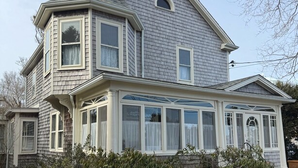 A two-story house with a prominent corner turret, large windows, and a covered front porch. - Charming studio in delightful Provincetown with WiFi, AC (Provincetown)