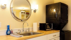 A kitchen with a sink, a microwave, and a black refrigerator. - Charming studio in delightful Provincetown with WiFi, AC (Provincetown)