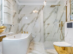 Ein modernes Badezimmer mit einer Marmerdusche, einer Badewanne und einem WC.