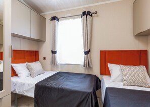 A hotel room with two beds, a window with curtains, and a wardrobe. - Luxurious Lodge, perfect for couples or familes, sleeping four people. (Nr Kintore)