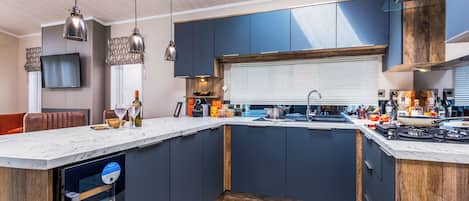 A modern kitchen with a central island, built-in appliances, and pendant lighting.