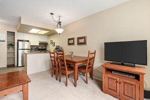 A compact living space with a dining area, kitchen, and entertainment unit. - 1BR + Sofabed | Marquise | Condo Close To Ski Hill | Fireplace | Hot Tub & Sauna | Gym (Whistler)