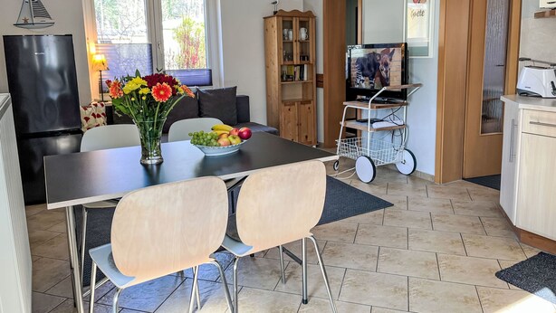 A modern kitchen with a dining area, a TV, and a fruit bowl on the table. - Dat lütt Huus by Interhome (Zinnowitz)