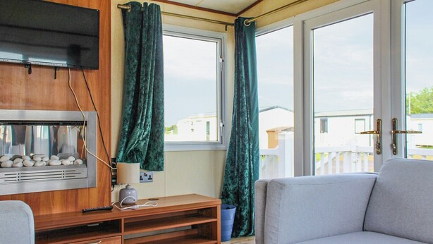 Una sala de estar con chimenea, un sofá y una ventana con cortinas.