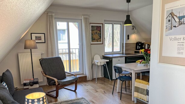 A cozy, well-lit apartment with a dining area, kitchenette, and a view of the outside. - Dat Huus by Interhome (Zinnowitz)