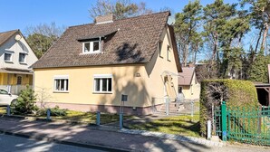 A two-story house with a sloped roof, a satellite dish, and a small garden area. - Dat Huus by Interhome (Zinnowitz)