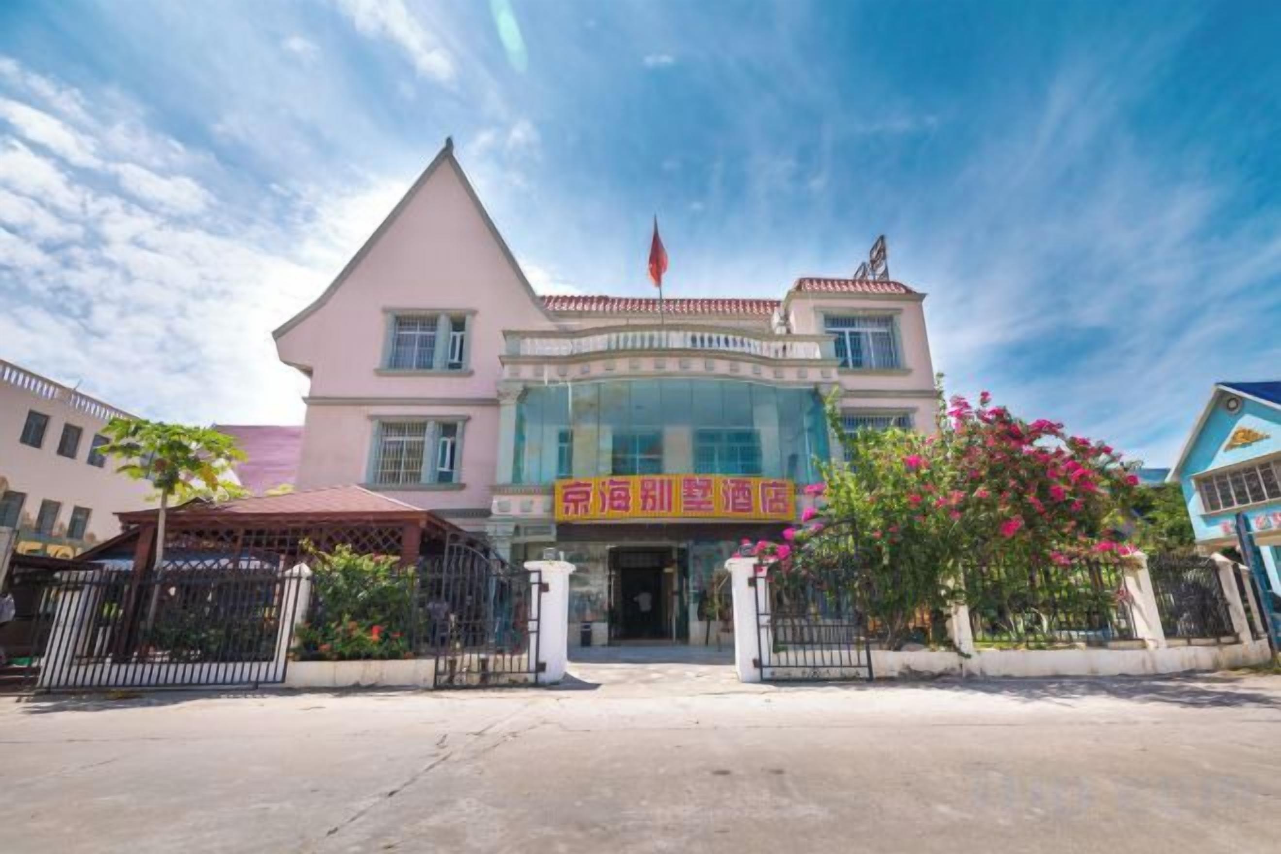 A hotel with a prominent entrance, a flag, and a signboard.