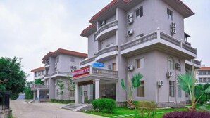 A multi-story building with balconies, air conditioning units, and a sign indicating a business establishment. - OYO Beihai Jinghai Villa (Yintan) (Beihai)