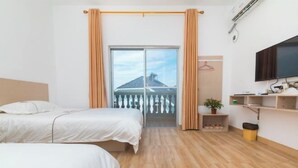A hotel room with two beds, a TV, a small shelf with items, and a balcony with curtains. - OYO Beihai Jinghai Villa (Yintan) (Beihai)