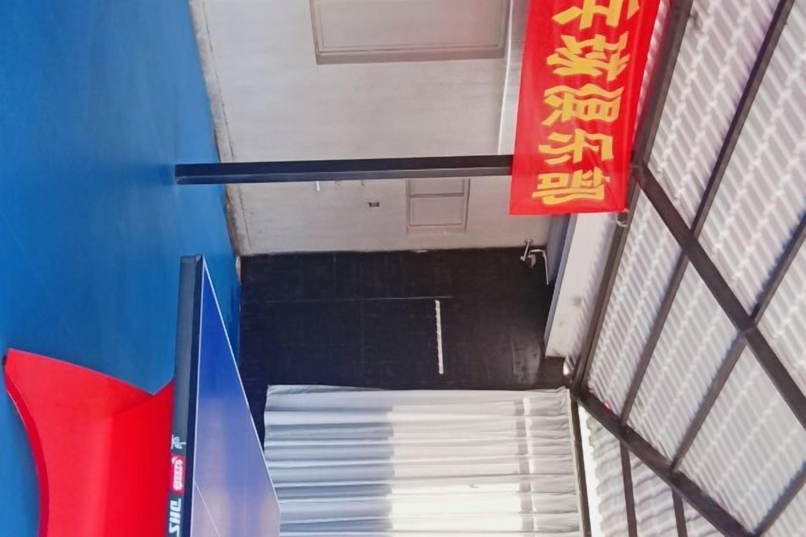 A room with a blue wall, a door, and a red sign with yellow text.