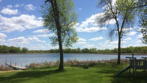 A lakeside deck with picnic tables and a playground.
