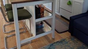 A compact kitchen with a wooden table, a built-in oven, and a stove. - Tiny, Funky, and Full of Love - Welcome to the Love Shack (Piney Point)
