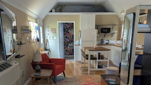 A compact living space with a kitchenette, a dining area, and a bedroom. - Tiny, Funky, and Full of Love - Welcome to the Love Shack (Piney Point)