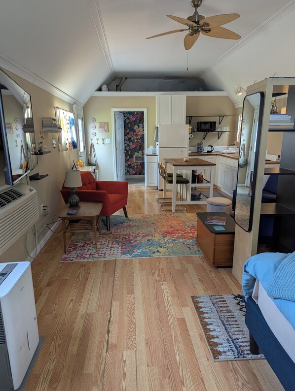 A compact living space with a kitchenette, a dining area, and a bedroom.