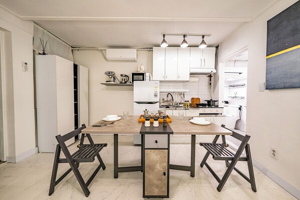 Una cocina moderna con armarios blancos, una isla central con asientos y una estufa.