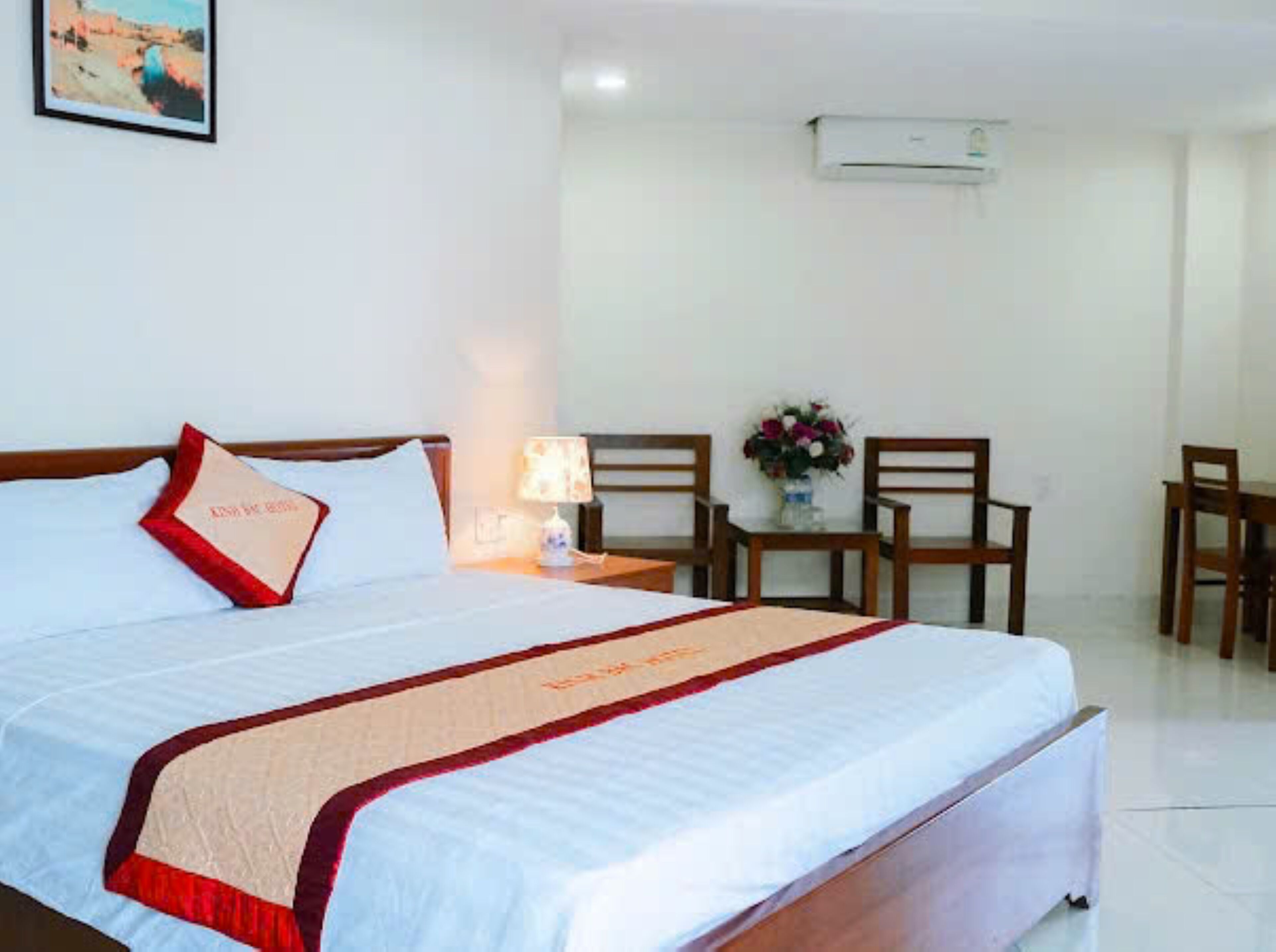 Quarto de hotel com cama, escrivaninha e uma cadeira.