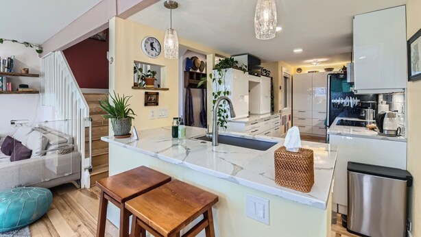 A modern kitchen with a central island, stainless steel appliances, and pendant lighting.