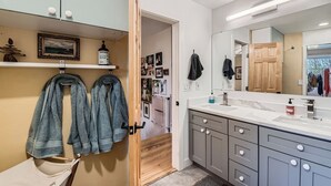 A modern bathroom with a vanity, mirror, and towel rack.