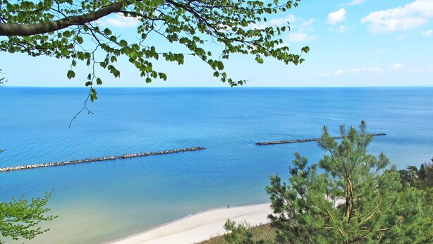 A beach with clear blue water, a sandy shore, and a rocky breakwater. - Vacation home Hammel by Interhome (Koserow)