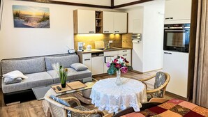 A compact living space with a sofa, dining table, and kitchen area. - Vacation home Hammel by Interhome (Koserow)
