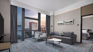 A modern hotel room with a large window, a sofa, a coffee table, and a bed. - Wanda Yue Nanchang Intl. Expo City (Nanchang)