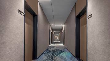Un largo y estrecho pasillo de hotel con puertas a ambos lados, numeradas 1219 y 1218.