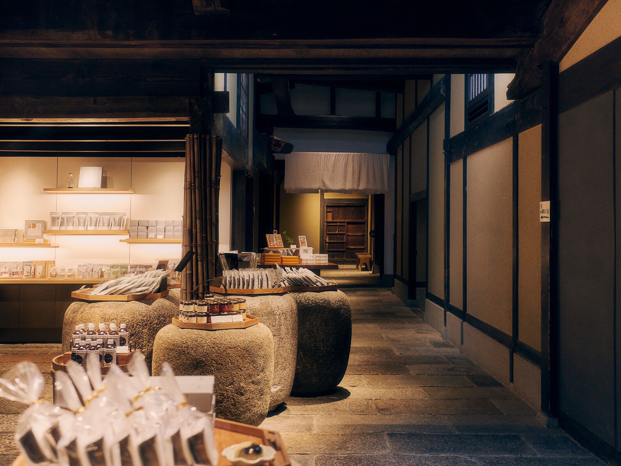 A traditional Japanese interior with tatami mats, a low wooden table, and shelves displaying tea sets and ceramics.
