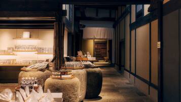 A traditional Japanese interior with tatami mats, a low wooden table, and shelves displaying tea sets and ceramics.