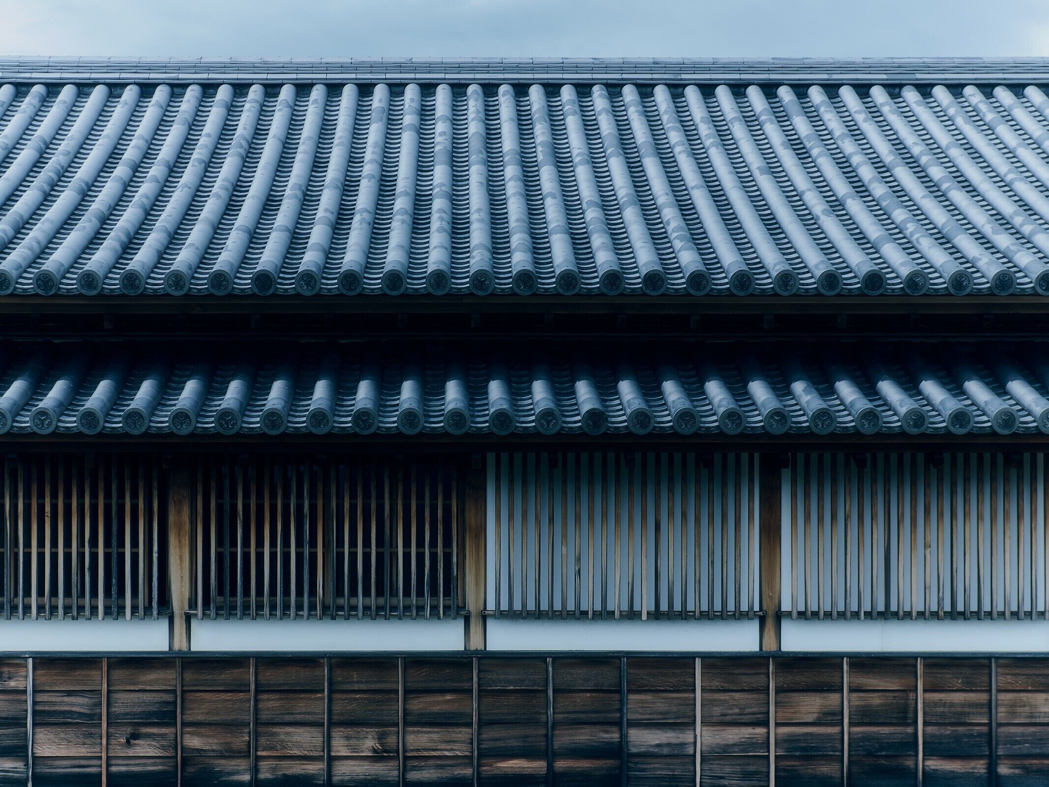 Un edificio japonés tradicional con tejado de baldosas y listones de madera.