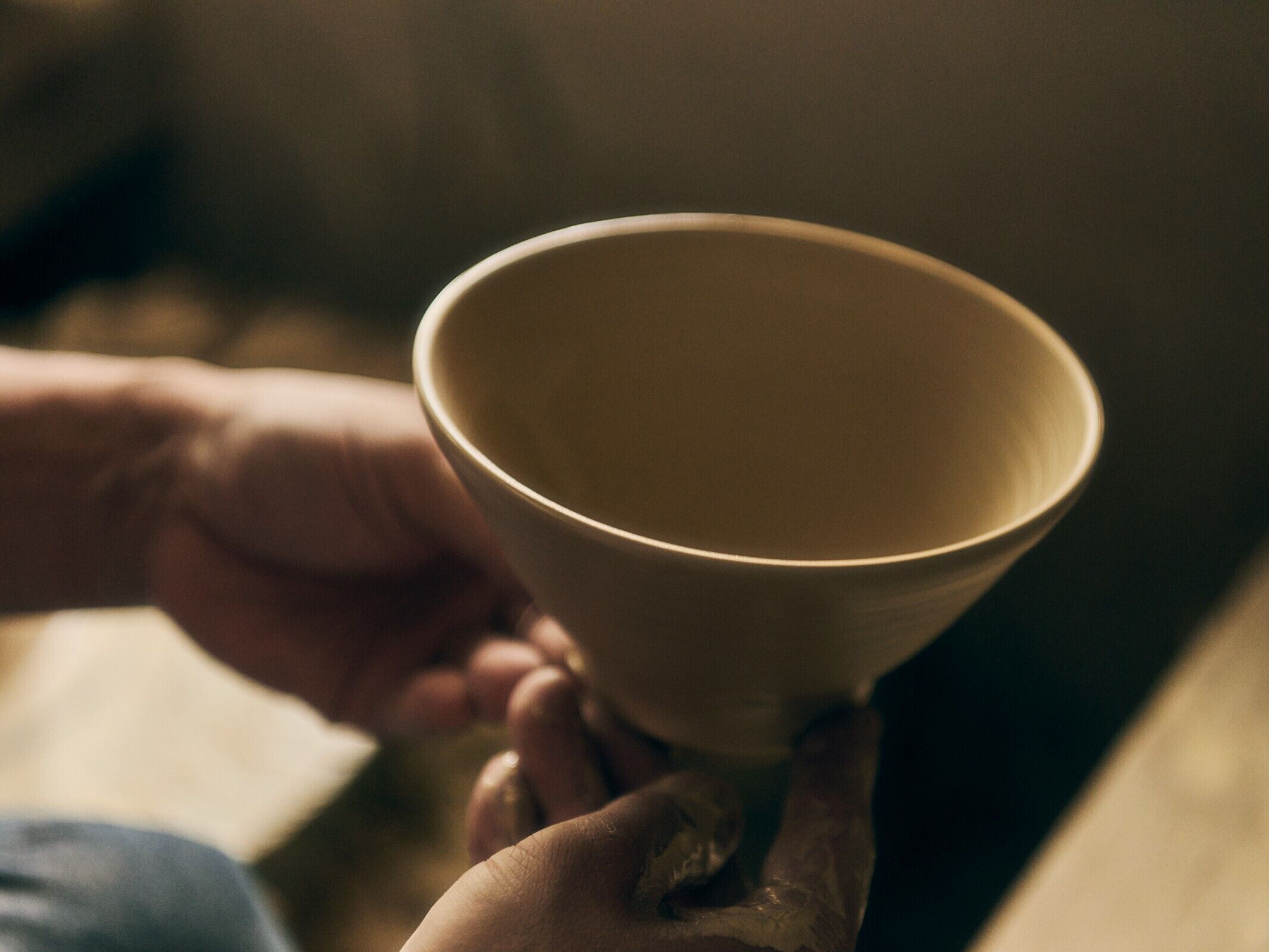 A hand holding a ceramic bowl.