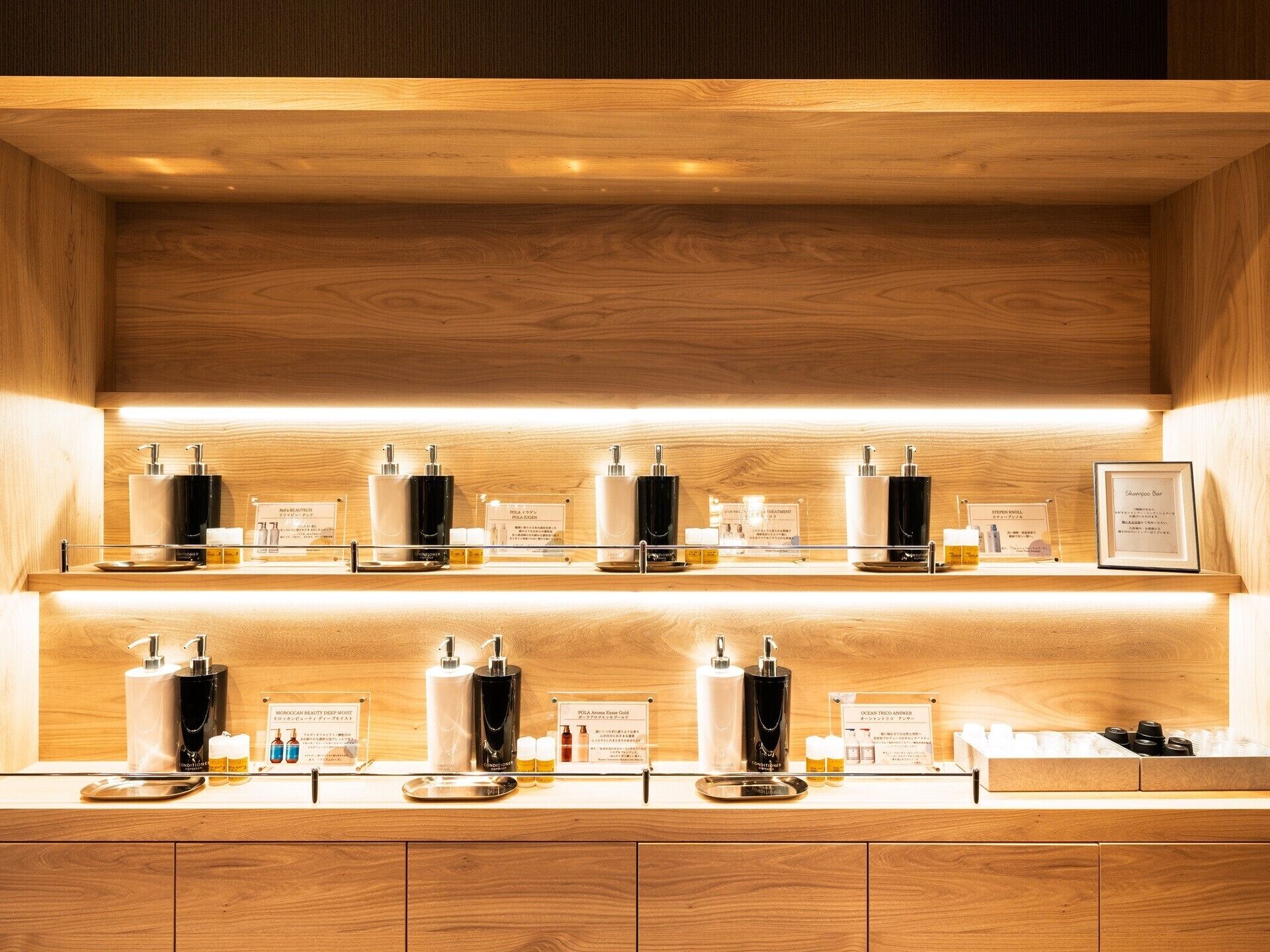 A well-organized shelf with various skincare products and a framed certificate.