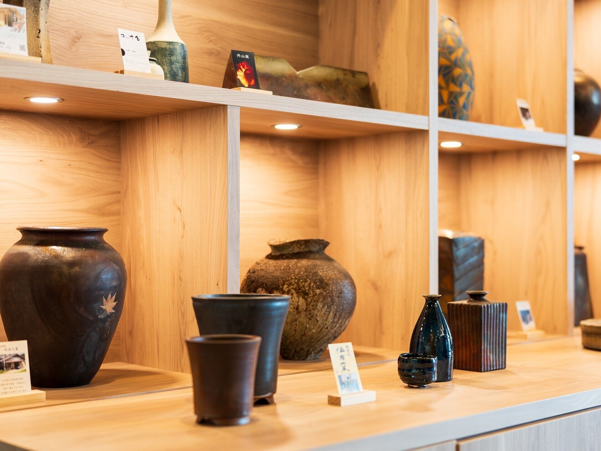 A display of various ceramic vases on shelves.