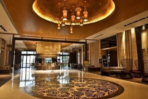 A spacious lobby with a circular patterned floor, a central chandelier, and seating areas. - Honghai Bay Haihang Holiday Hotel (Huidong)
