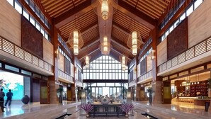 A spacious lobby with high ceilings, large windows, and a central seating area. - Honghai Bay Haihang Holiday Hotel (Huidong)