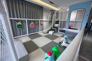 A children's play area with a slide, soft play equipment, and a netted play zone. - Honghai Bay Haihang Holiday Hotel (Huidong)