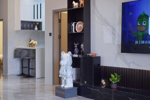 A modern hotel lobby with a reception desk, a seating area, and a television screen. - Honghai Bay Haihang Holiday Hotel (Huidong)