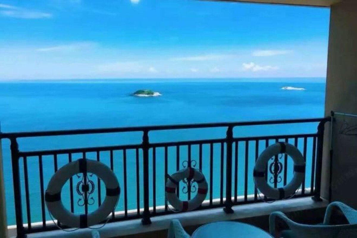 Un balcone con vista sull'oceano, caratterizzato da tre ringhiere metalliche circolari e un salvagente.