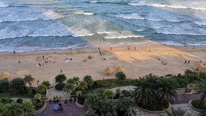 A beach with people, palm trees, and a view of the ocean. - Honghai Bay Haihang Holiday Hotel (Huidong)