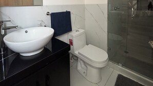 A modern bathroom with a white sink, black countertop, and a glass shower enclosure. - Departamento de una habitación en Roma Sur CDMX (Ciudad de México)