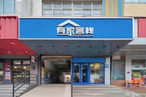 A hotel entrance with a blue sign, a covered entrance, and a staircase leading up. - Shijiangzhuang Youjia Inn Eryuan Branch (Shijiazhuang)