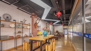 A modern interior with a wooden table, shelves with decorative items, and a brick wall. - Shijiangzhuang Youjia Inn Eryuan Branch (Shijiazhuang)