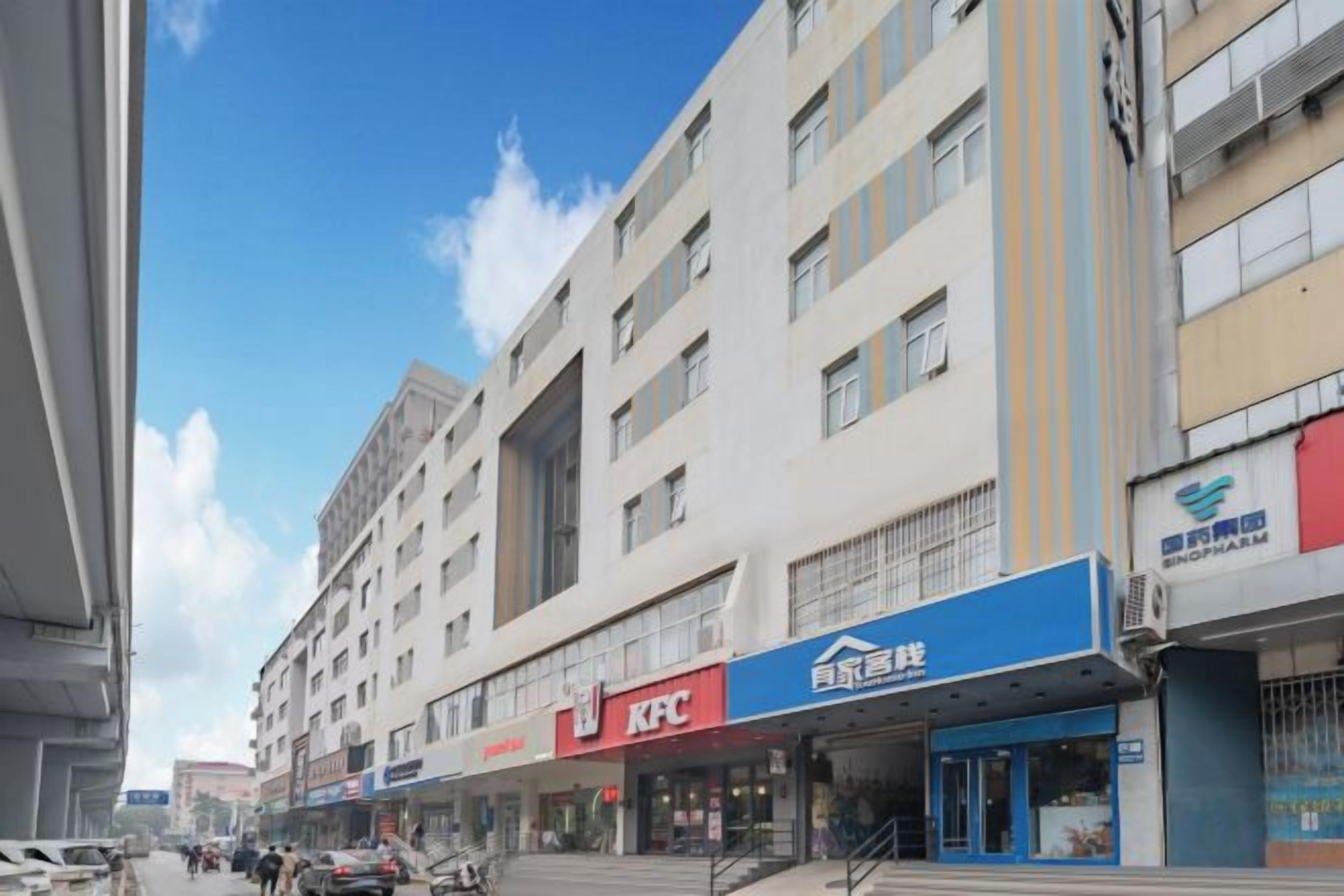 Un edificio de varios pisos con locales comerciales en la planta baja, incluyendo un KFC y un banco.